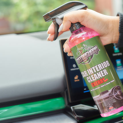A person is using Car interior cleaner spray bottle with cherry scent in a car 